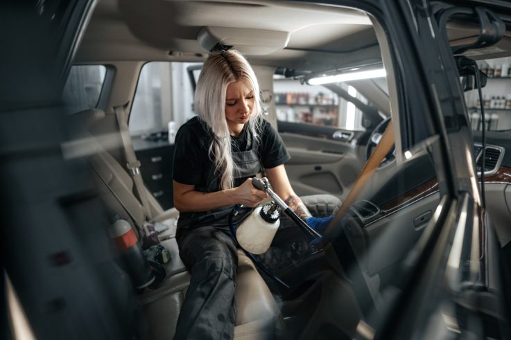 Woman detailing car seatbelt. How often should you detail your car?